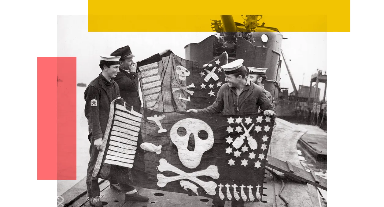Royal Navy Submariners hold their jolly roger flags