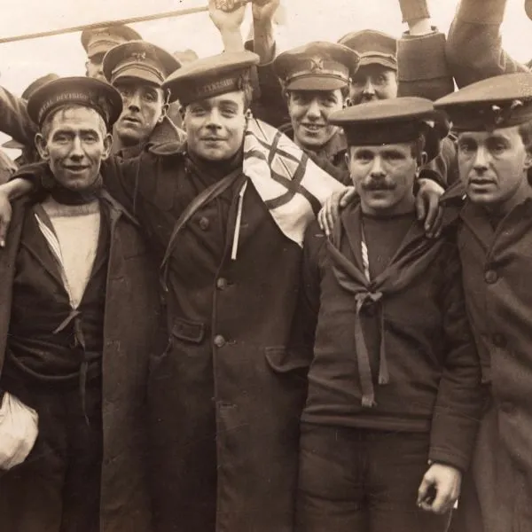 A group of British prisoners of War, recently repatriated from Germany, gather smiling and embracing as they celebrate their return home